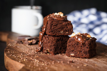 Brownies on wooden board. Homemade chocolate cake brownie squares. Closeup view, selective focus