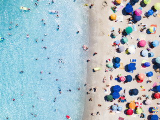 View from above, aerial view of an emerald and transparent Mediterranean sea with a white beach full of beach umbrellas and tourists who relax and swim.Sardinia, Italy. © Travel Wild