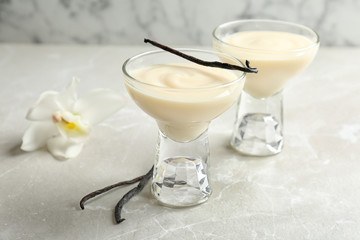 Vanilla pudding, sticks and flower on table