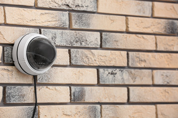 Modern security CCTV camera on brick wall