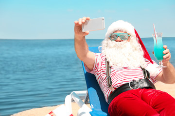 Obraz premium Authentic Santa Claus taking selfie at resort