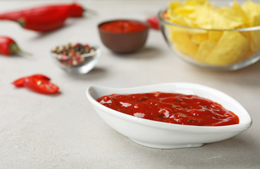 Gravy boat with spicy chili sauce on light table