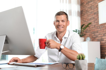Young man working with computer in home office