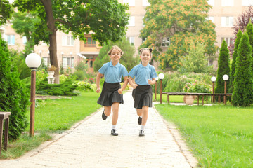 Little girls in stylish school uniform outdoors