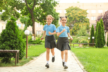 Little girls in stylish school uniform outdoors