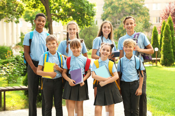 Group of children in stylish school uniform outdoors - obrazy, fototapety, plakaty