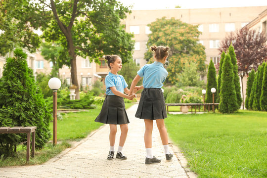 Little girls in stylish school uniform outdoors