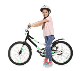 Portrait of cute little girl with bicycle on white background