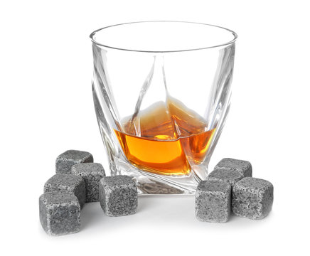 Glass with liquor and whiskey stones on white background