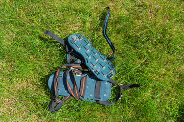 Spiked lawn revitalizing aerating shoes, gardening concept. Garden care.