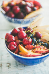 Healthy breakfast smoothie bowl with fresh fruit, berries and honey on wooden background, top view, selective focus, vertical composition. Clean eating, weight loss, fitness nutrition concept