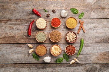 Flat lay composition with different aromatic spices on wooden background