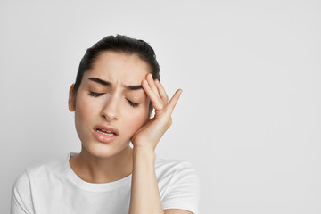 women headache with eyes closed holding head
