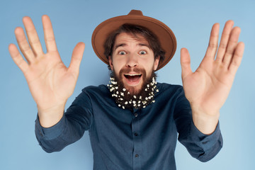 joyful man in a hat with flowers in his beard spring