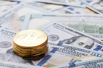 Bitcoins on dollar banknotes background