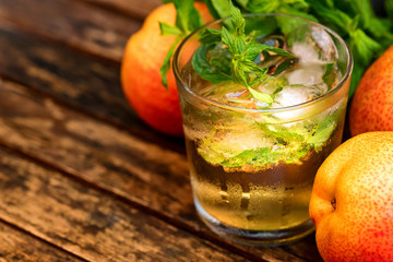 Ripe pears and pear drink on a wooden table