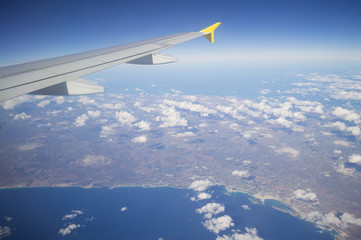 Obraz premium Aerial View of Italian Coastline with Wing of Plane in Flight