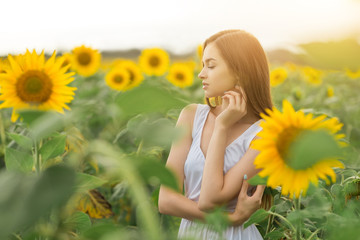 Obraz na płótnie Canvas beautiful girl in a field of sunflowers