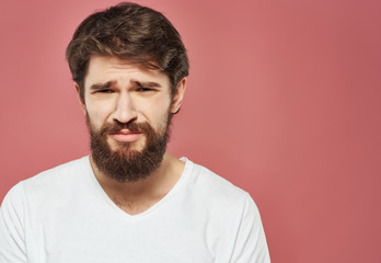 Obraz premium man with a beard on a pink background emotions