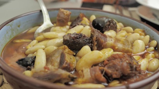 CLOSE UP FOOD: National Northern Spanish dish: Fabada, in a round white plate