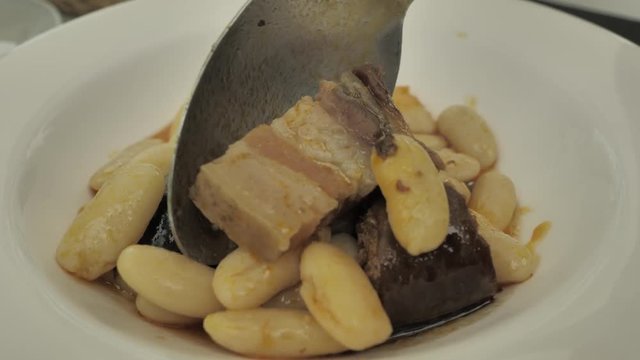 CLOSE UP FOOD: National Northern Spanish dish: Fabada, in a round white plate