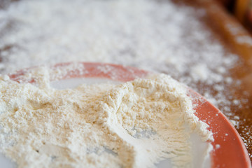 Top side view on white flour on rustic wooden table background, closeup of healthy cooking copyspace surface at home or restaurant.
