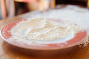 Top side view on white flour on rustic wooden table background, closeup of healthy cooking copyspace surface at home or restaurant.