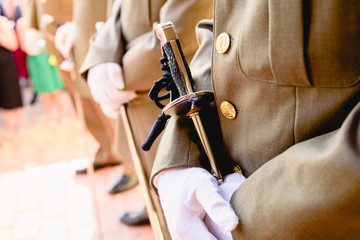 Army soldiers with gloves holding their sabers waiting to be checked by the superior