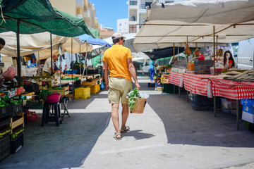 Adult person shopping buying fresh fruits vegetables food abstract background, light day shop market. Selecting choosing green commodity groceries, life consumption, checkout purchase.
