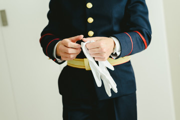 Military man hands putting on some elegant white gloves.