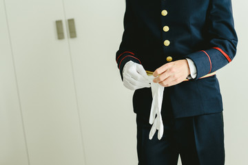 Military man hands putting on some elegant white gloves.