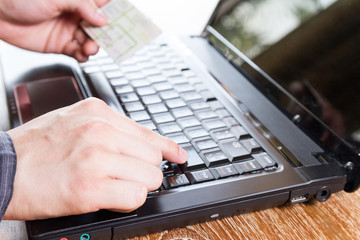 Fototapeta na wymiar hand holding credit card and using laptop computer