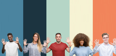 Group of people over vintage colors background showing and pointing up with fingers number ten while smiling confident and happy.