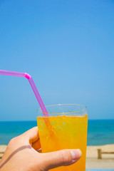 Orange juice drinking on the beach. ビーチで飲むオレンジジュース