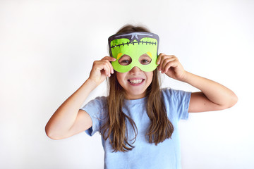 The girl plays the fool in a mask of the monster for Halloween
