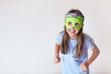 The girl plays the fool in a mask of the monster for Halloween
