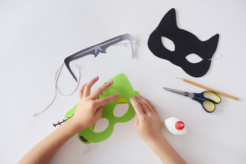 Making masks  paper  holiday Halloween Monster's  mask Black cat  Hands top view 