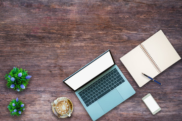 Laptop on Vintage Wooden desktop in modern office with accessories - top view on desk from above.	