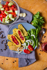 Crispy corn breads slices. Spicy and tasty on plate with green salad leaves, onion rings and tomatoes. Vegan lunch or vegetarian dinner. Healthy food concept.