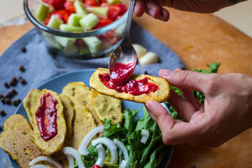 Crispy corn breads slices. Spicy and tasty on plate with green salad leaves, onion rings and tomatoes. Vegan lunch or vegetarian dinner. Healthy food concept.