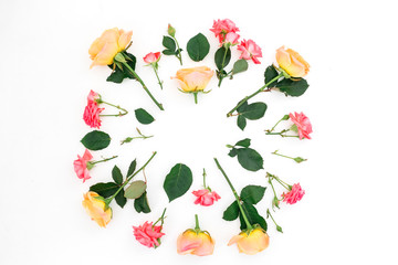 Composition with pink and orange roses flowers, buds and green leaves on white background. Flat lay, top view