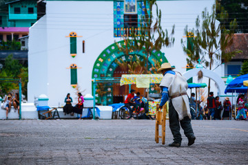Señor camina con bastón frente al templo principal  de San Juan Chamula Chiapas.