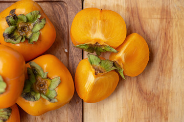 Fresh ripe persimmons on blue wooden table