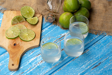 Lime juice and lemon on a blue wooden table