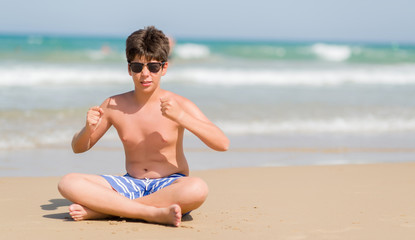 Fototapeta na wymiar Young child on holidays at the beach annoyed and frustrated shouting with anger, crazy and yelling with raised hand, anger concept