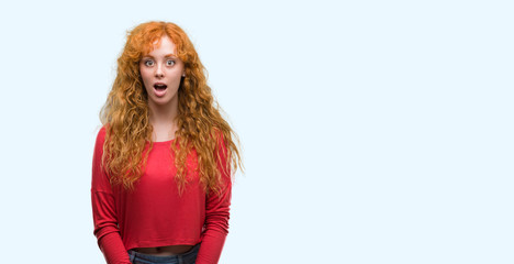 Young redhead woman scared in shock with a surprise face, afraid and excited with fear expression