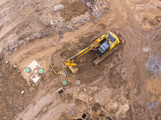 top view of construction area. yellow excavator doing earthmoving works.