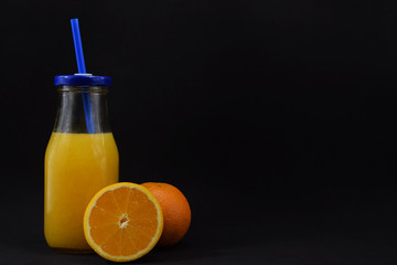 A glass with fresh aleklin juice and an orange lies beside it.