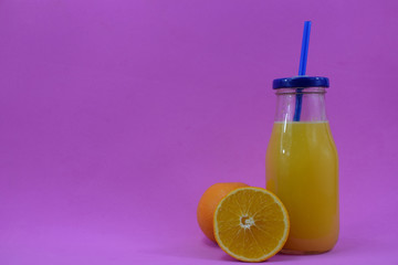 A glass with fresh aleklin juice and an orange lies beside it.