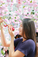 Obraz premium Close-up female holding rose on a sunny day. Surrounds the flowering.